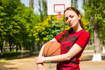 Young Woman Holding Basketball on Outdoor Court