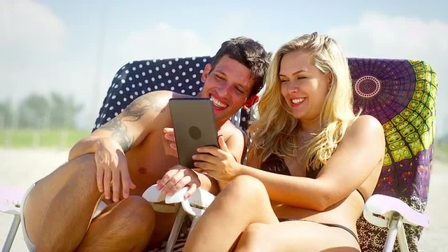 Brazilian couple using technology on a beach in Brazil