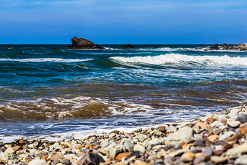 Fototapeta na wymiar Wild stone beach and rock in water