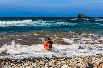 Surfer with a surfboard in Atlantic ocean coast