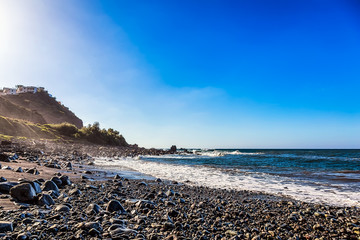 Fototapeta na wymiar Wild stone beach on shore of ocean