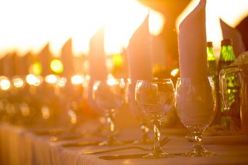 Served table for banquet on background of golden sunset