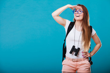 Tourist woman with binoculars on blue