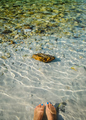 feet and clear water with stones