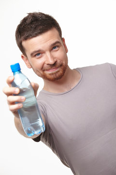 smiling young man showing water bottle