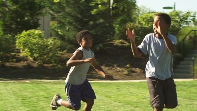 A father plays football with his family, and throws a pass to his son.