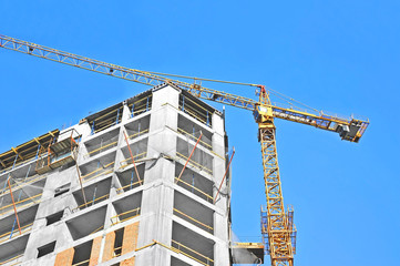 Crane and building construction site against blue sky