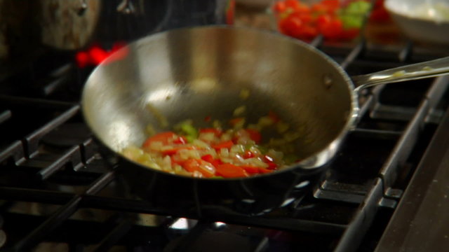 Vegetables in a skillet erupt in flame