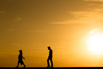 Fototapeta premium Silhouette people walking at sunset