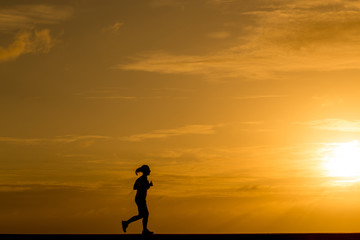 Silhouette women jogging at sunset