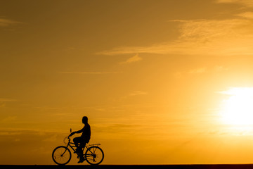 Fototapeta na wymiar Silhouette man riding the bike at sunset