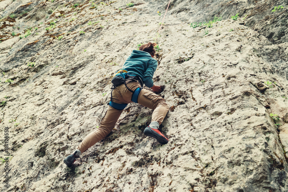 Sticker Active young woman climbing on rock