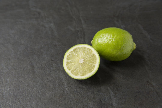 Fresh ripe lime on slate background