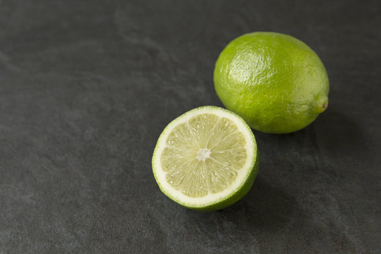 Fresh ripe lime on slate background