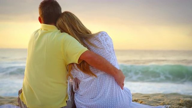 Brazilian couple embrace and look out over the ocean