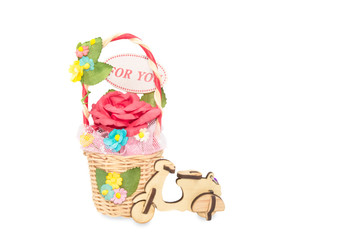 artificial roses in rattan basket with wooden toy motorcycle iso