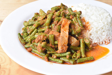 stir fried pork with yard long bean and red curry on white plate