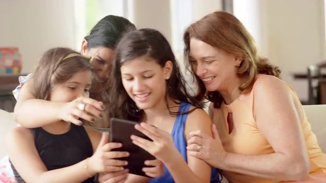 Generations of women using a tablet computer to take pictures