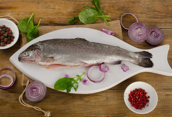 Raw Rainbow trouts on a  white cutting board.