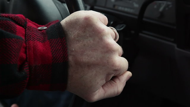 A man driving chooses a radio station to listen to and grabs the wheel and swerves to avoid an accident