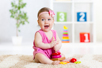 cute baby playing with colorful toy pyramid