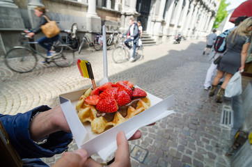 Obraz premium Belgijski gofr z sosem czekoladowym i truskawkami