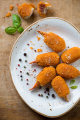 Close-up of roasted breaded crab claws on a plate, above view