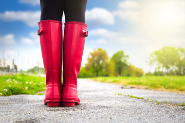 Young woman in pink rain boots walking. detail of boots.