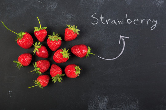 Concept of strawberries on dark chalkboard