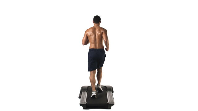Wide shot of an athletic ethnic man running on a treadmill