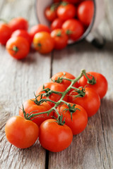 Fresh cherry tomatoes on grey wooden background