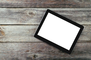 Tablet computer with white screen on grey wooden background