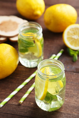 Fresh lemonade with lemon on brown wooden background
