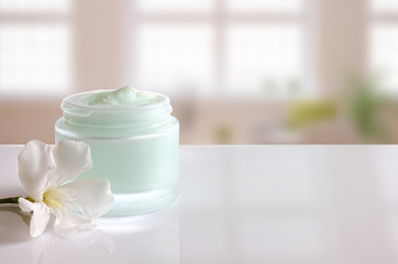Cream jar open with flower front view windows background