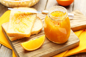 Bread and orange jam on grey wooden background