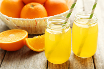 Orange juice in bottle on grey wooden background