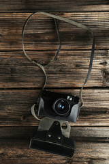 Old retro camera on brown wooden background