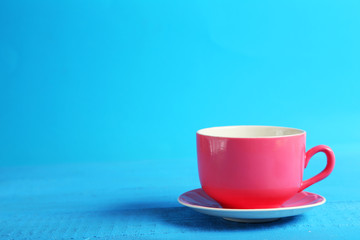 Pink cup on blue wooden background