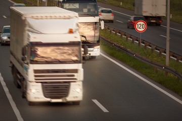 White truck in motion blur and bus on highway