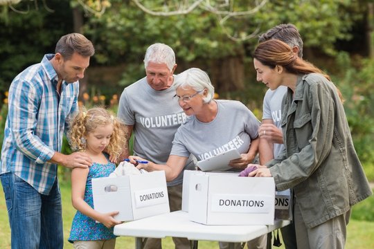 Happy volunteer family separating donations stuffs