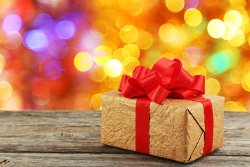 Gift box with red bow on grey wooden background