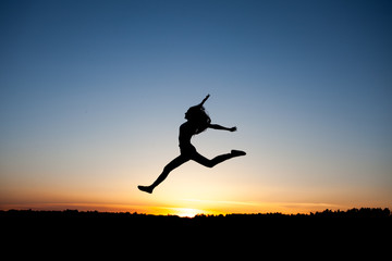 silhouette of female dancer in sunset sky