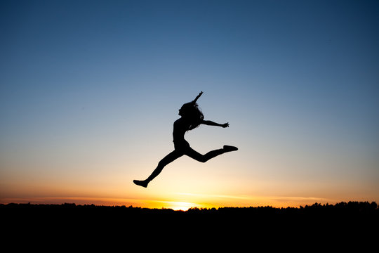 silhouette of female dancer in sunset sky