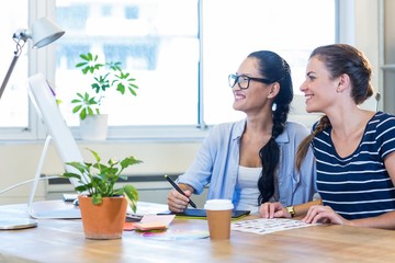 Obraz premium Smiling partners working together on computer and digitizer