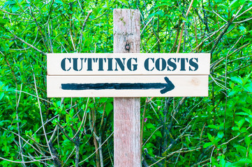CUTTING COSTS Directional sign