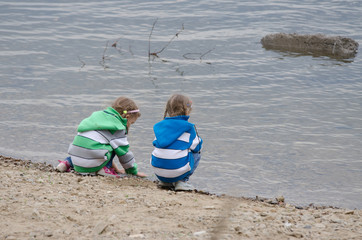 Two girls sitting on a river bank