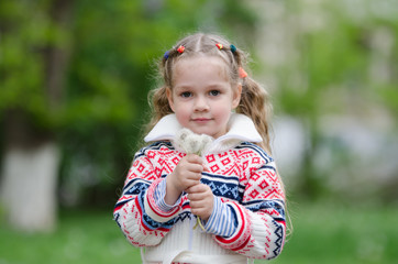 Portrait four-year girl with bouquet white dandelions 