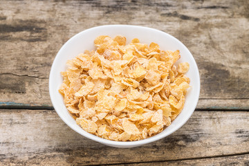 Healthy breakfast background. Corn flakes in white bowl 