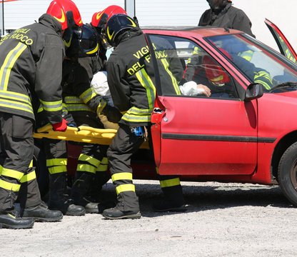 firefighters in action and pull the injured from the car