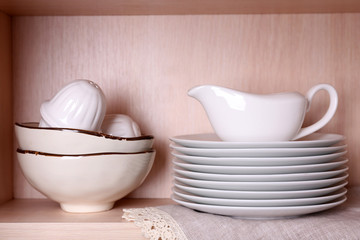 Fototapeta na wymiar Kitchen utensils and tableware on wooden shelf